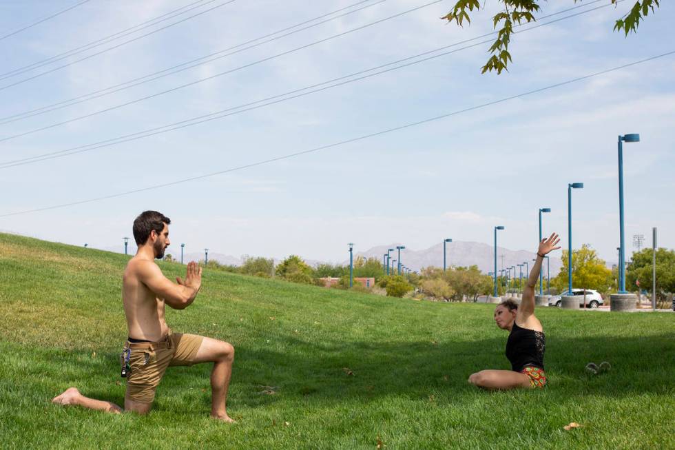 Tyler Bryce, left, and Natalie Kleinman, right, practice yoga despite an excessive heat warning ...