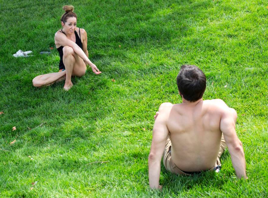 Natalie Kleinman, left, and Tyler Bryce, right, practice yoga despite an excessive heat warning ...