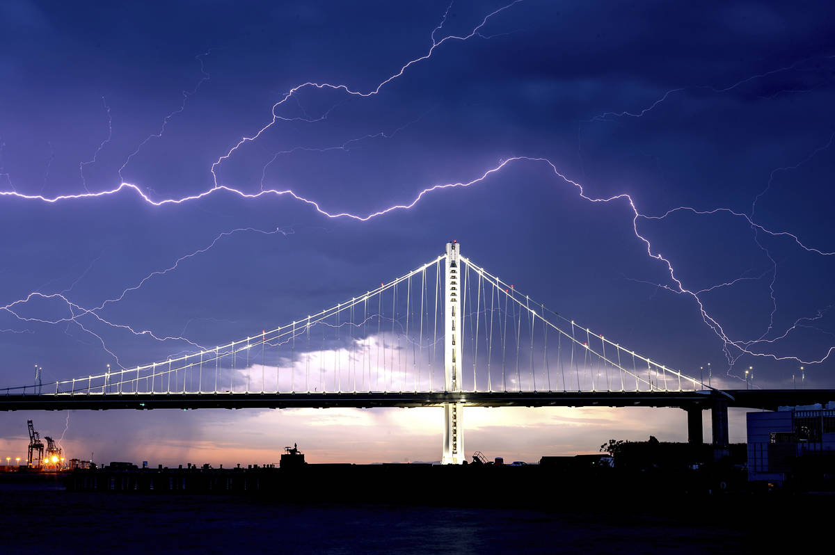 Lightning forks over the San Francisco-Oakland Bay Bridge as a storm passes over Oakland, Calif ...