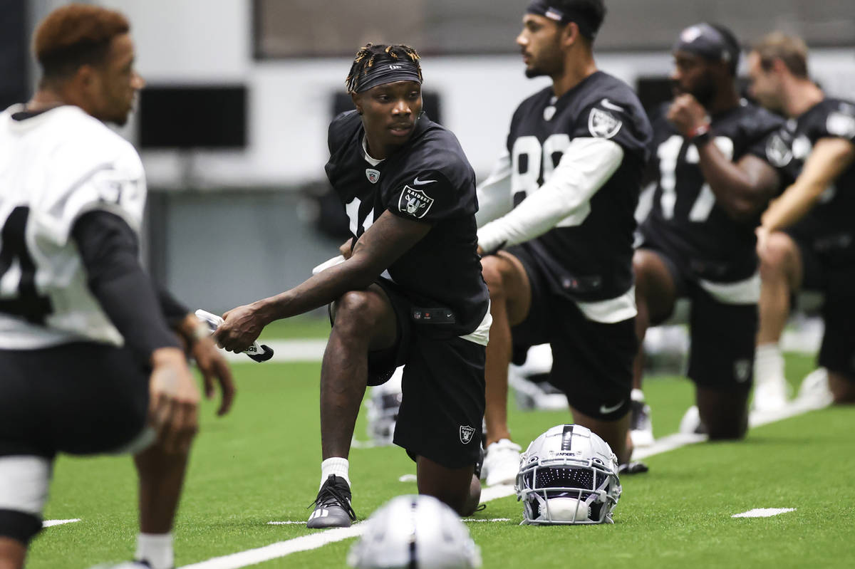 Las Vegas Raiders wide receiver Henry Ruggs III (11) stretches with teammates during an NFL tra ...