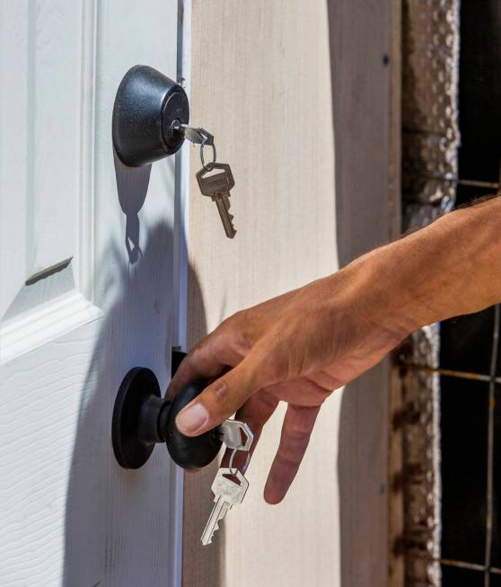 Robert Majors makes sure the keys work on a new hut for the homeless joined by other with other ...