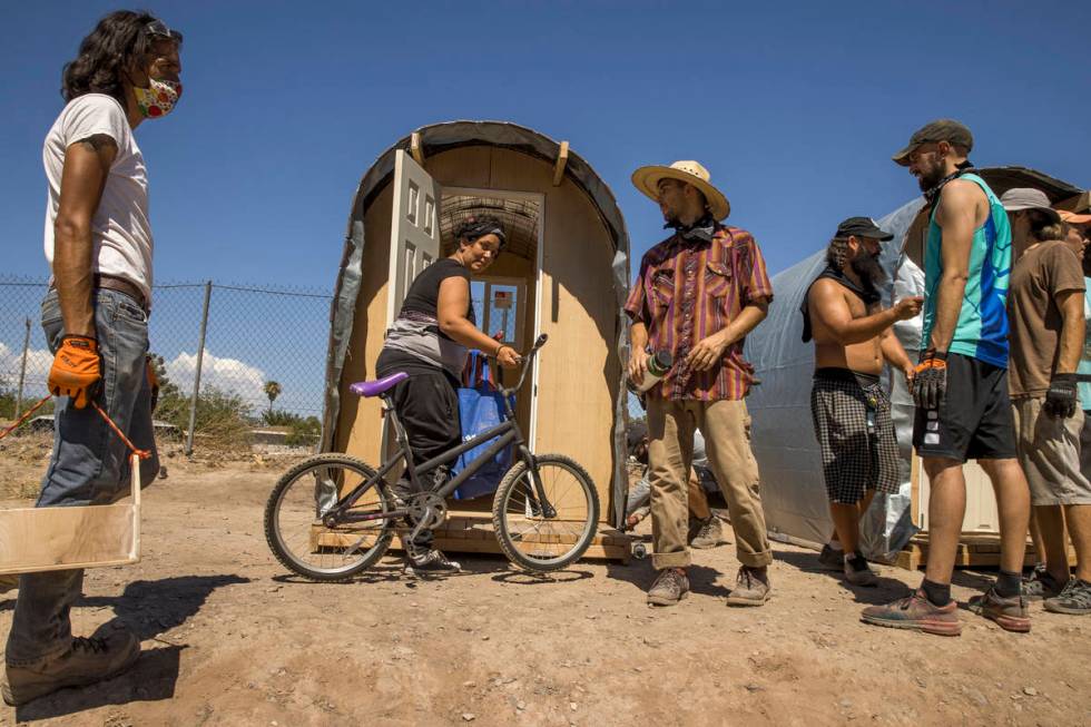 New hut resident Angelica Peacock, center left, looks on as members of Food Not Bombs and the S ...