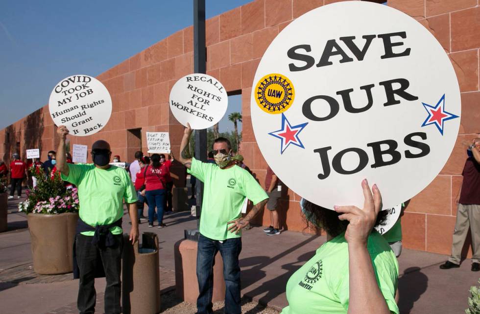 Alex Santana, left, Jim Soldate and Donna Blair, right, rally outside of the Clark County Commi ...