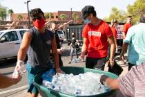 Volunteers Christopher Hughes, left, and his brother Declan hand out bottles of water to union ...