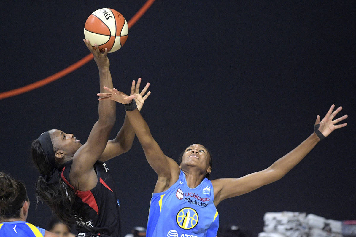 Las Vegas Aces guard Jackie Young, left, goes up for a shot in front of Chicago Sky forward Azu ...
