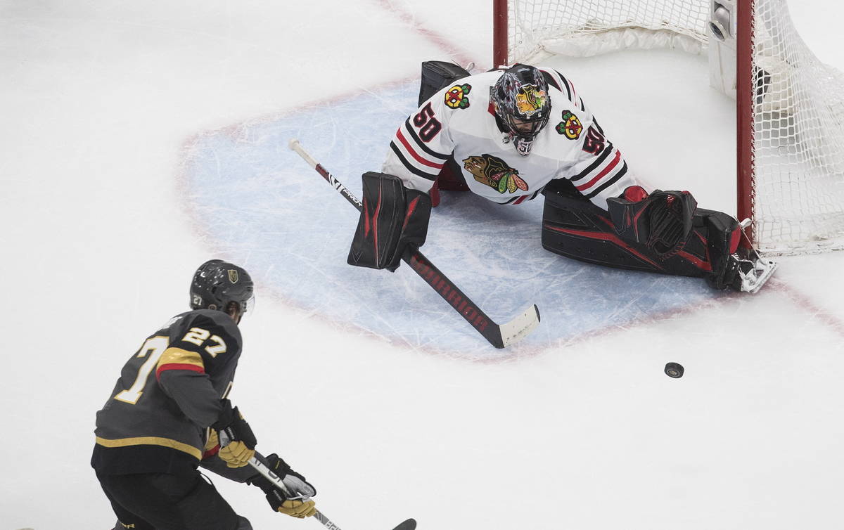 Vegas Golden Knights' Shea Theodore (27) is stopped by Chicago Blackhawks goalie Corey Crawford ...