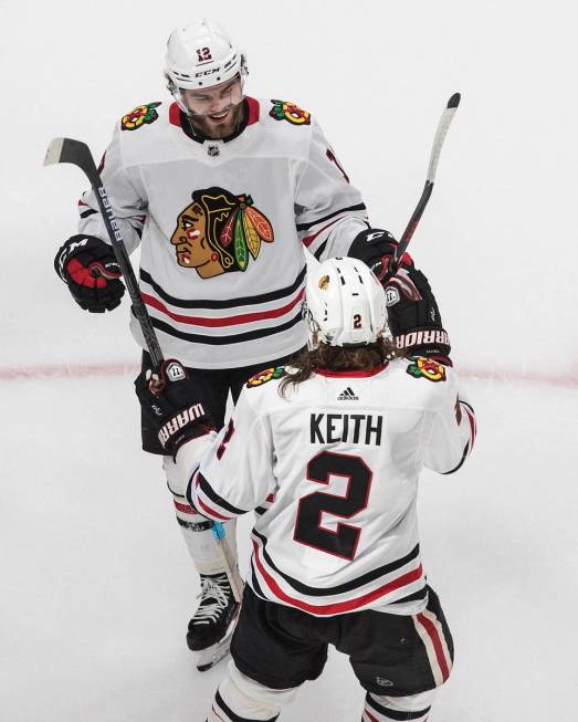 Chicago Blackhawks' Alex DeBrincat (12) and Duncan Keith (2) celebrate a goal against the Vegas ...