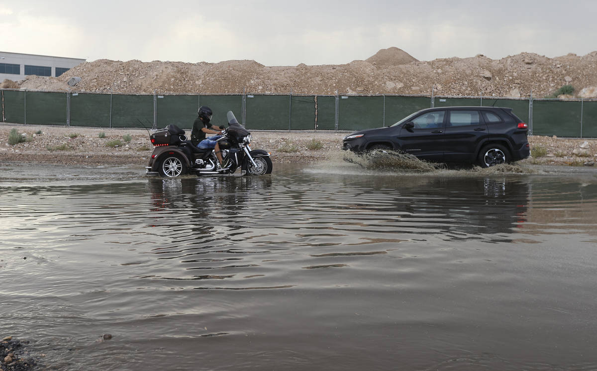 Cars move through a flooded portion of Buffalo Drive near Post Road in Las Vegas on Wednesday, ...