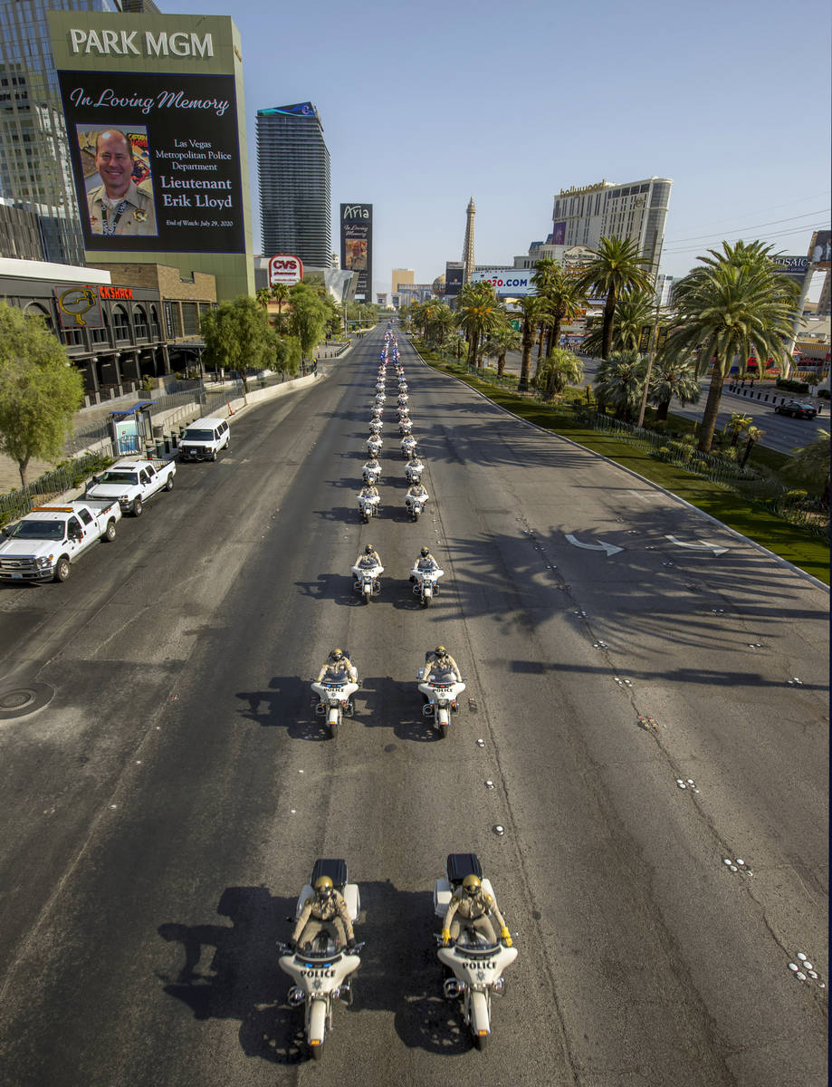 Motorcycle officers lead an emergency vehicles escort during a funeral procession for Las Vegas ...