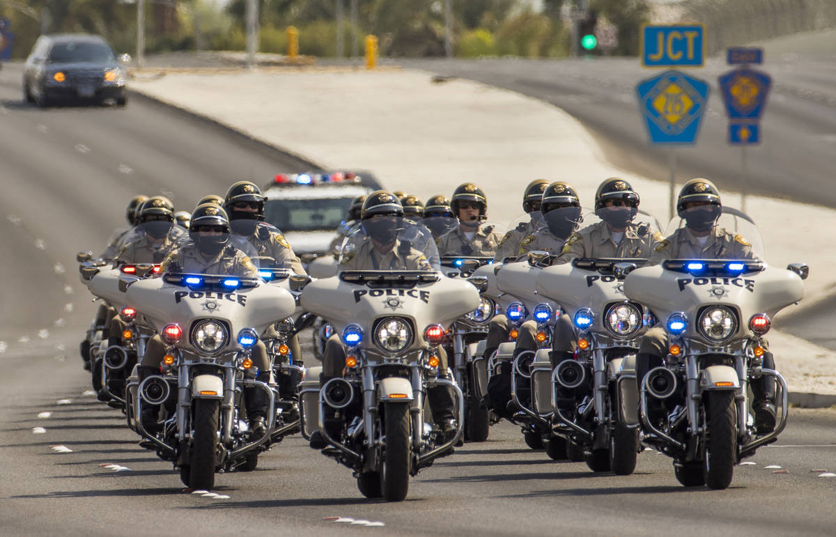 Metro motorcycle officers lead a white hearse arriving for a burial service for Metro Lt. Erik ...
