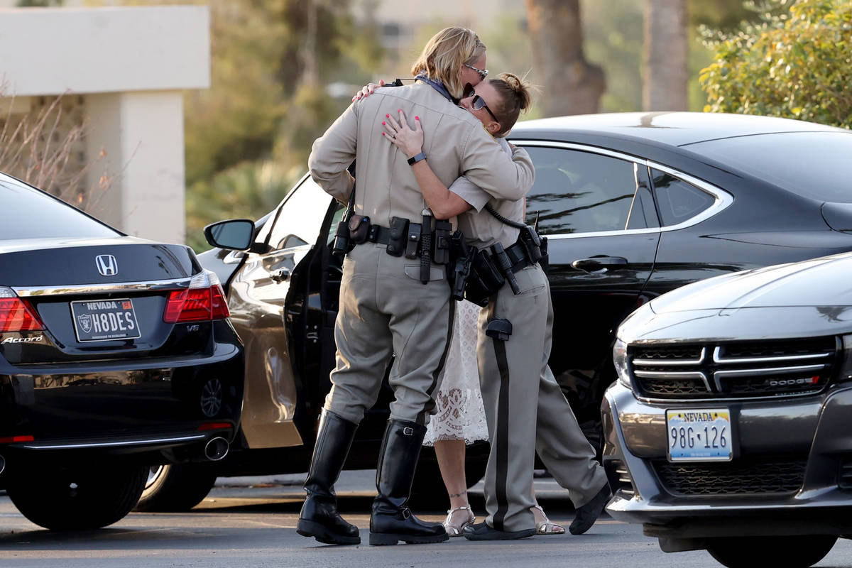 Las Vegas police officers Kelly Cannon, left, and Helene Wright hug as law enforcement personne ...