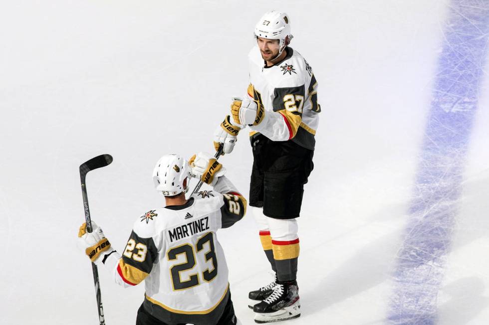 Vegas Golden Knights' Shea Theodore (27) and Alec Martinez (23) celebrate a goal during first-p ...