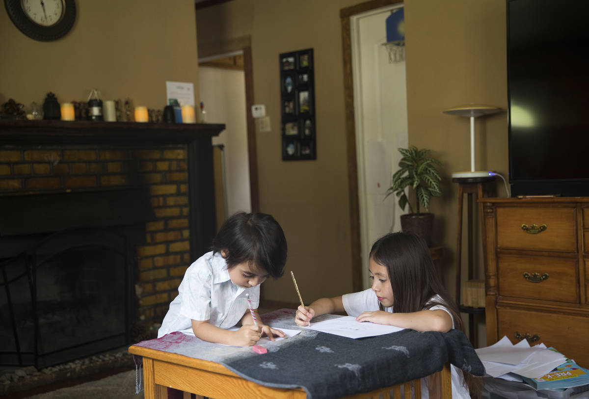 Sofia Hall, 8, right, draws with her brother Felix Hall, 4, left, at their home in Las Vegas, W ...