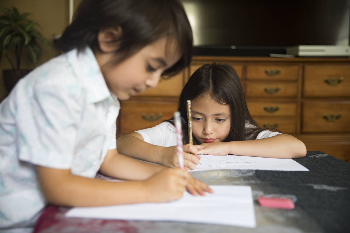 Sofia Hall, 8, right, draws with her brother Felix Hall, 4, left, at their home in Las Vegas, W ...