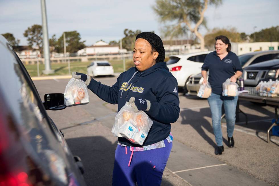 Clark County School District employees hand out breakfast and lunch packages to families at Cla ...