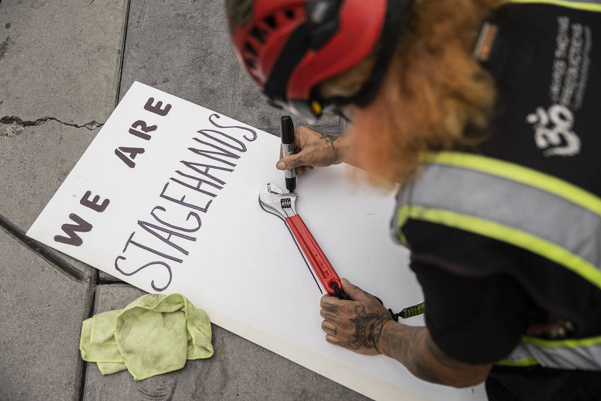 A stagehand named “Troll” makes a sign during an event to raise awareness about t ...