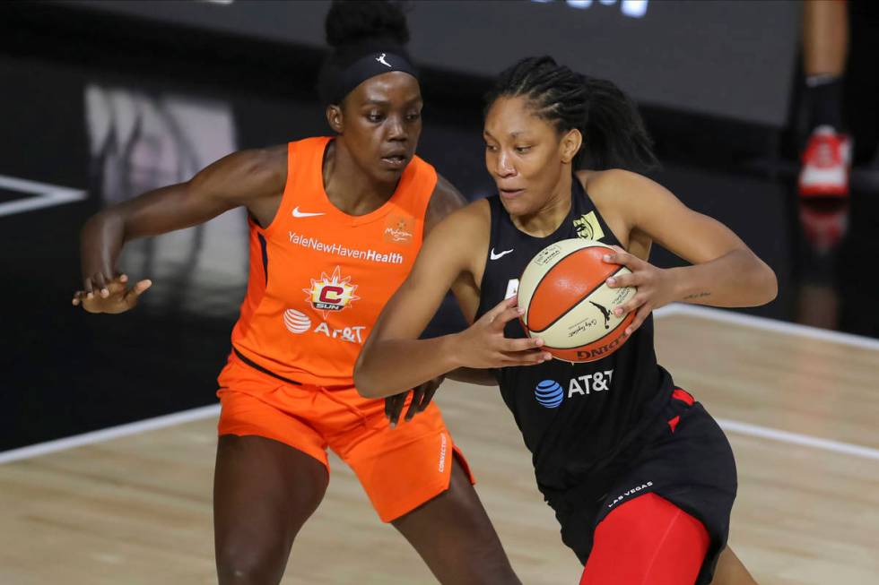 Las Vegas Aces' A'ja Wilson, right, drives against Connecticut Sun's Beatrice Mompremier during ...