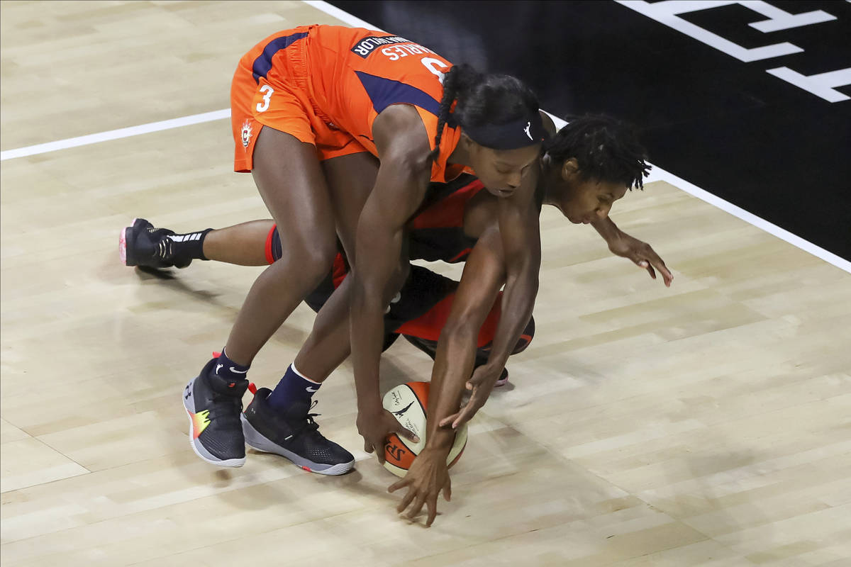 Las Vegas Aces' Angel McCoughtry dives for a loose ball under Connecticut Sun's Kaila Charles ( ...
