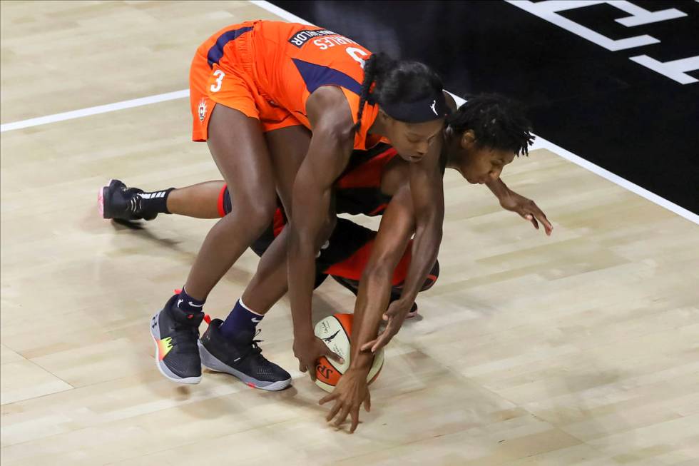 Las Vegas Aces' Angel McCoughtry dives for a loose ball under Connecticut Sun's Kaila Charles ( ...