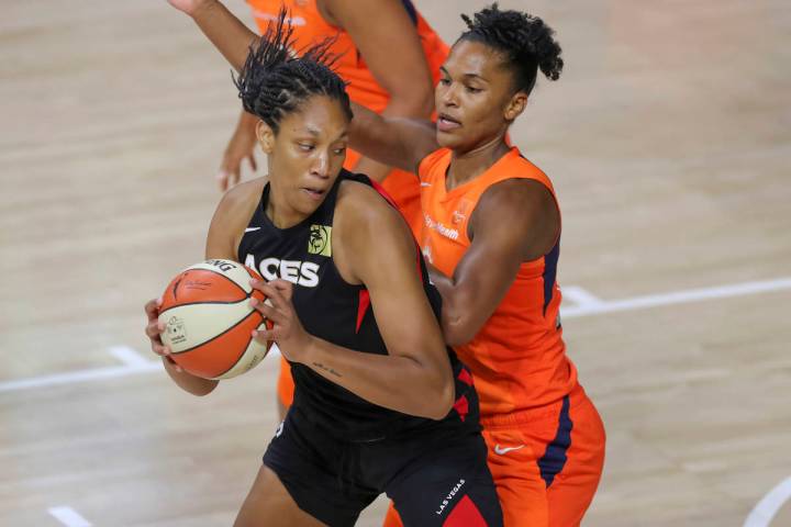 Las Vegas Aces' A'ja Wilson, left, drives against Connecticut Sun's Alyssa Thomas during the fi ...