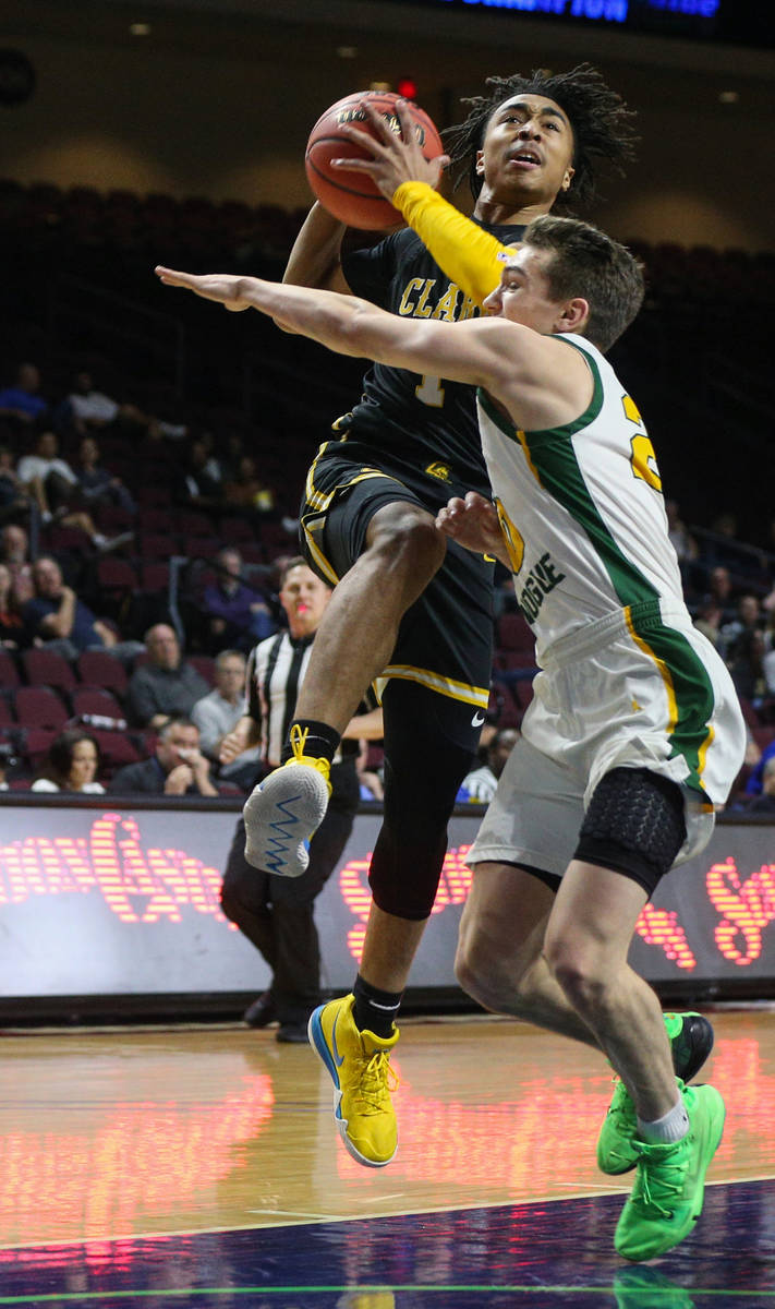 Clark's Frankie Collins (1) jumps up to take a shot while being guarded by Bishop Manogue's Cor ...