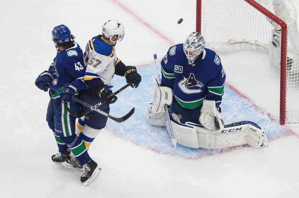 Vancouver Canucks' Quinn Hughes (43) and St. Louis Blues' David Perron (57) battle as Canucks g ...