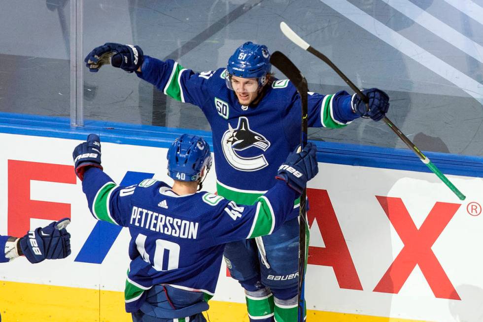 Vancouver Canucks' Troy Stecher (51) and Elias Pettersson (40) celebrate a goal against the St. ...