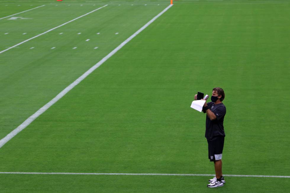 Raiders offensive coordinator Greg Olson takes photos prior a Las Vegas Raiders team practice a ...