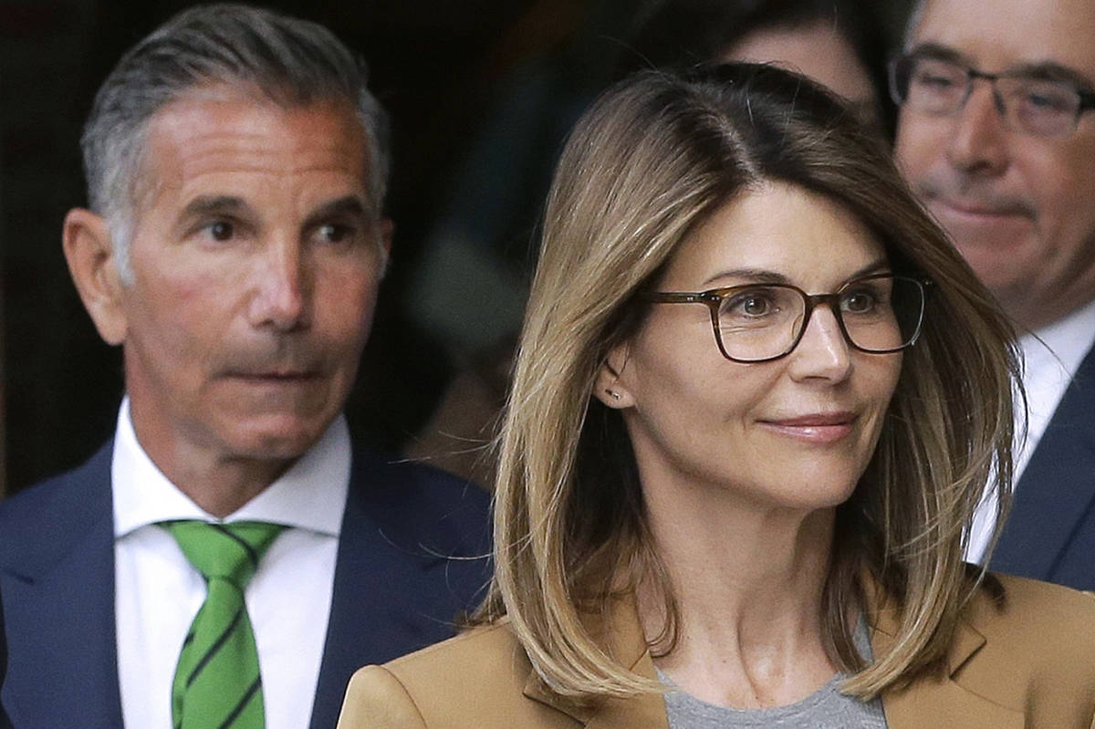 Actress Lori Loughlin, front, and her husband, clothing designer Mossimo Giannulli, left, depar ...