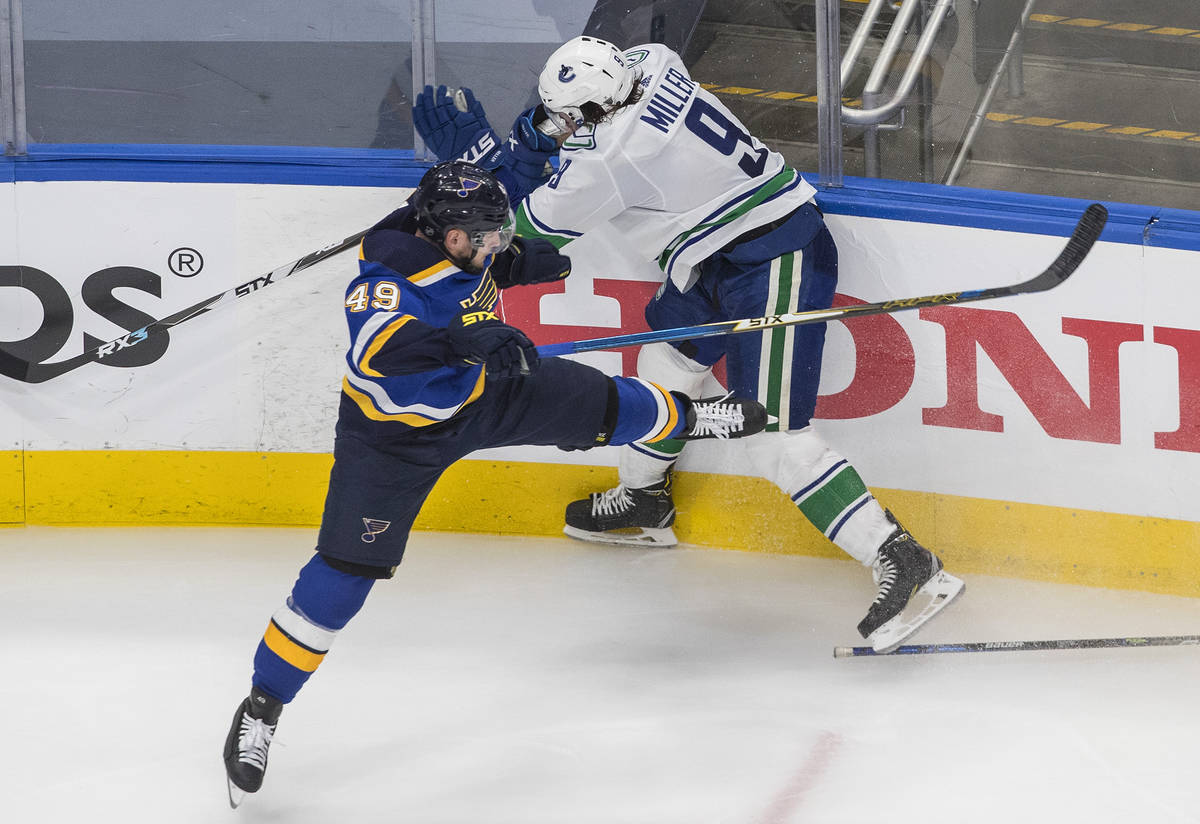 St. Louis Blues' Ivan Barbashev (49) checks Vancouver Canucks' J.T. Miller (9) during the third ...