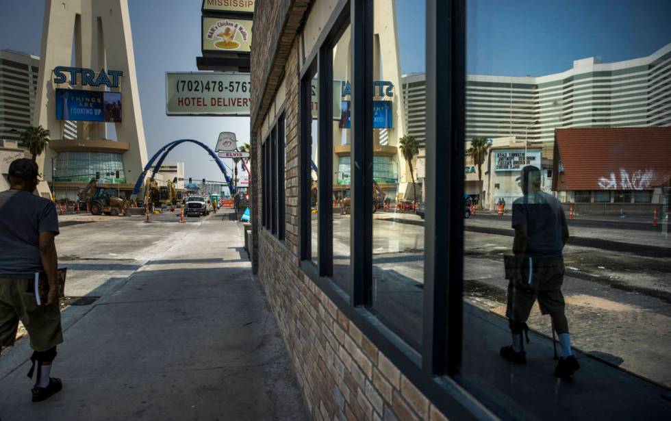 A pedestrian is reflected in a window as he walks towards the construction of the 80-foot-tall ...