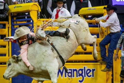 Clayton Sellars of Fruitland Park, Fla., clings to his ride in Bull Riding at the tenth go roun ...