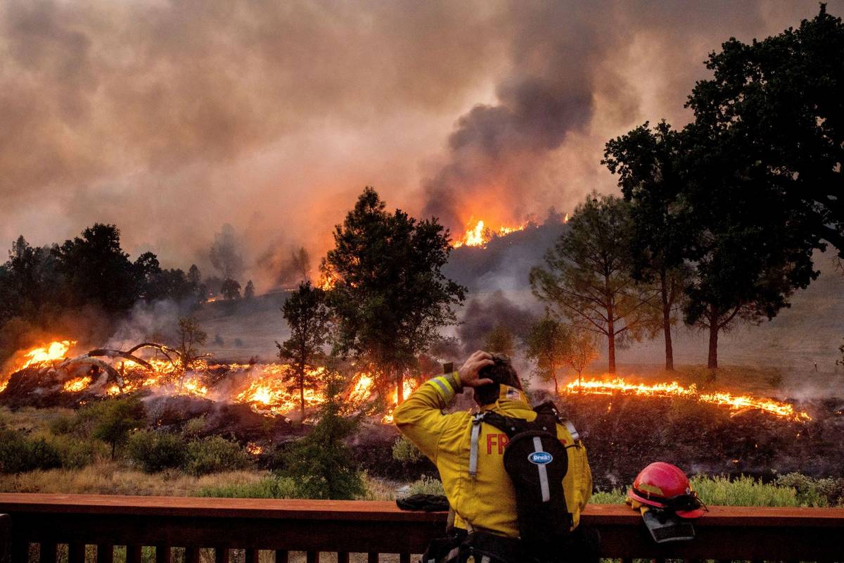 A firefighter rubs his head while watching the LNU Lightning Complex fires spread through the B ...