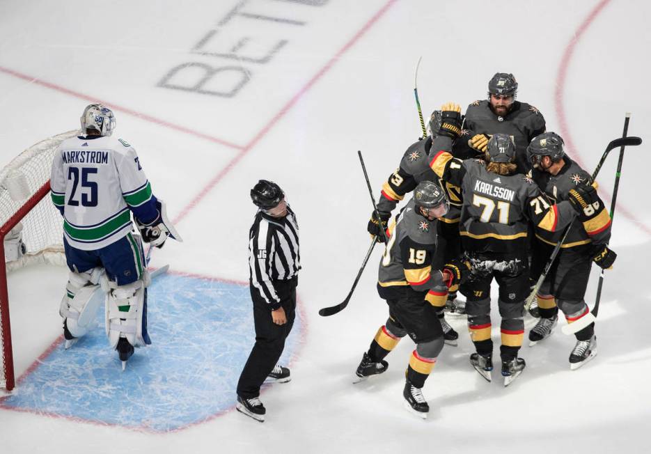 Vegas Golden Knights celebrate a goal on Vancouver Canucks goalie Jacob Markstrom (25) during t ...