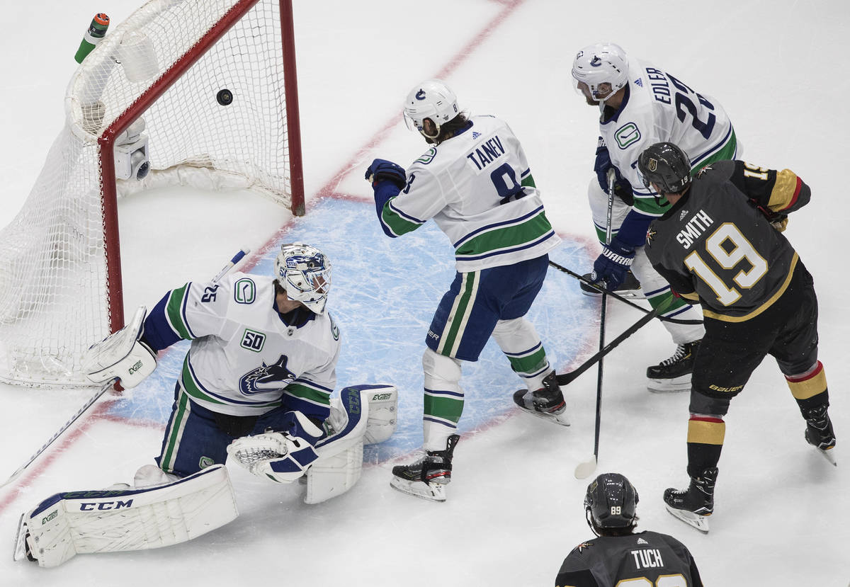 Vegas Golden Knights' Reilly Smith (19) scores on Vancouver Canucks goalie Jacob Markstrom (25) ...