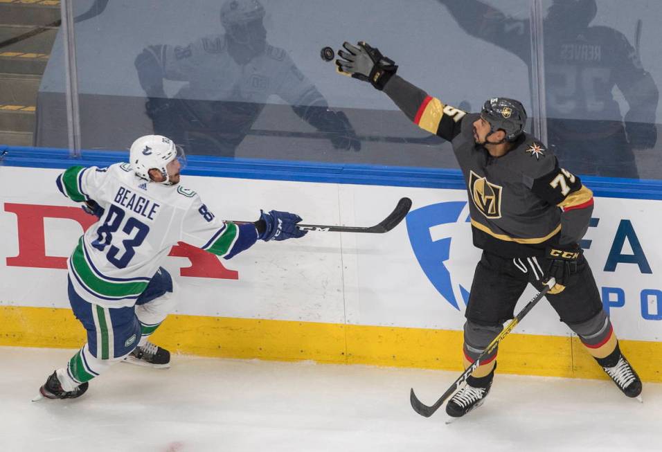 Vegas Golden Knights' Ryan Reaves (75) catches the puck as Vancouver Canucks' Jay Beagle (83) m ...