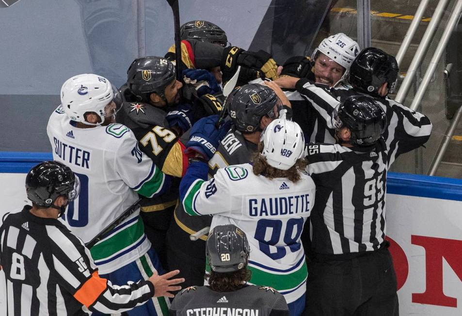 Vegas Golden Knights' Ryan Reaves (75) and Vancouver Canucks' Antoine Roussel (26) rough it up ...