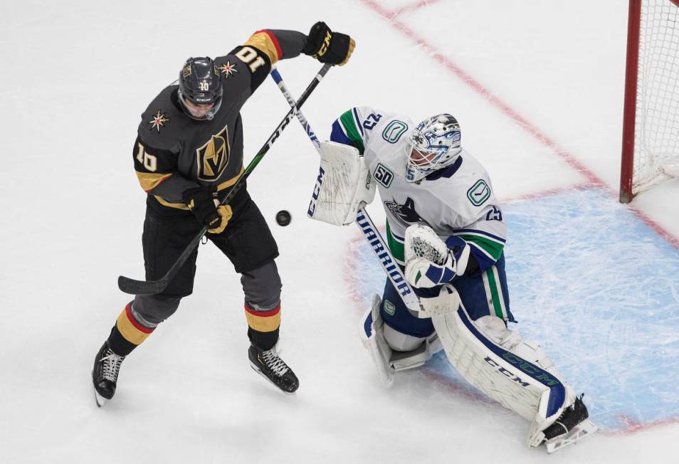 Vegas Golden Knights' Nicolas Roy (10) screens as Vancouver Canucks goalie Jacob Markstrom (25) ...