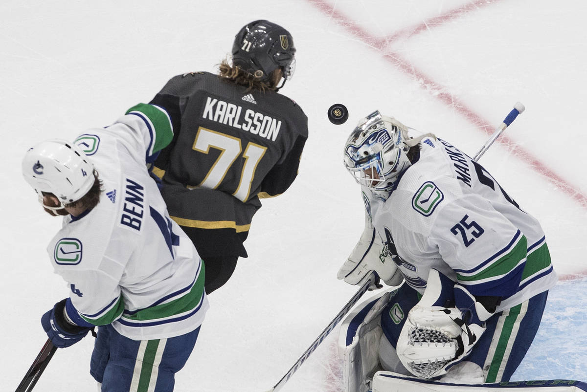 Vegas Golden Knights' William Karlsson (71) and Vancouver Canucks' Jordie Benn (4) battle in fr ...