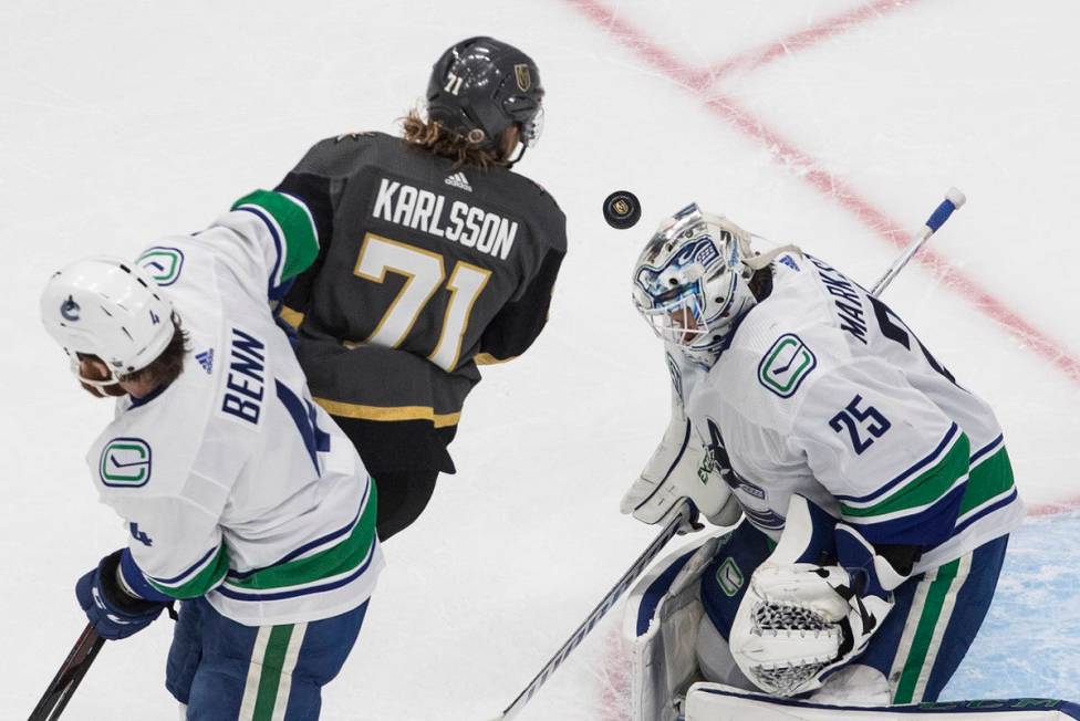 Vegas Golden Knights' William Karlsson (71) and Vancouver Canucks' Jordie Benn (4) battle in fr ...