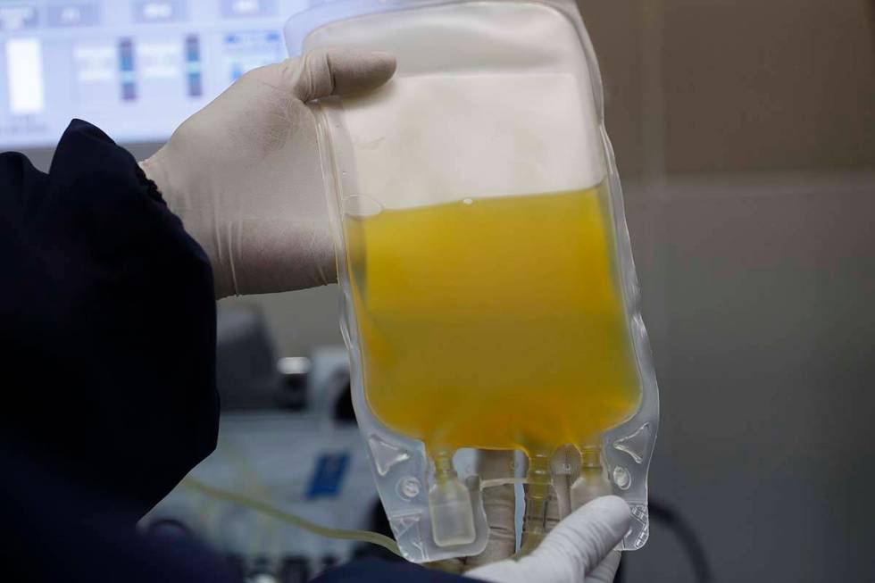 In this Friday, June 12, 2020 file photo, a doctor holds a bag of blood plasma donated by a COV ...