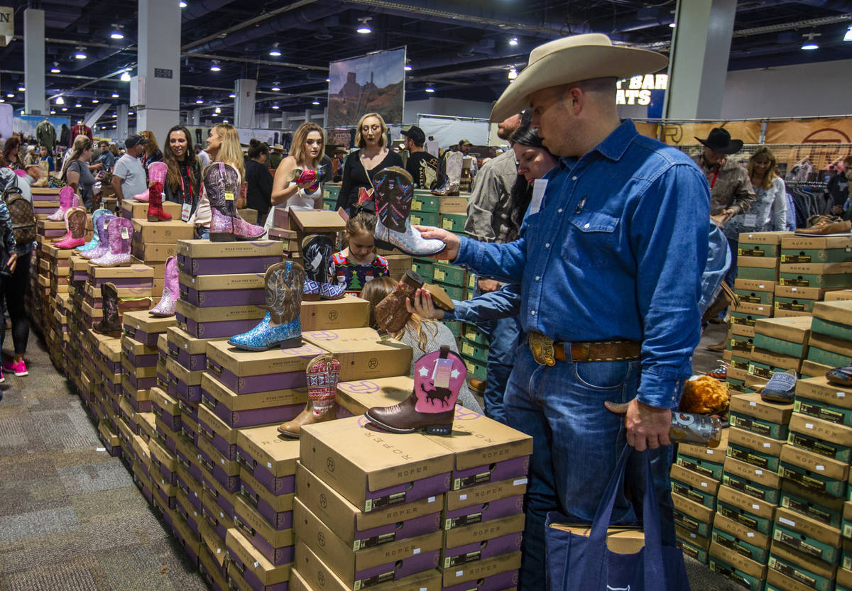 Shoppers check out the variety of Roper Boots for sale during Cowboy Christmas at the Las Vegas ...