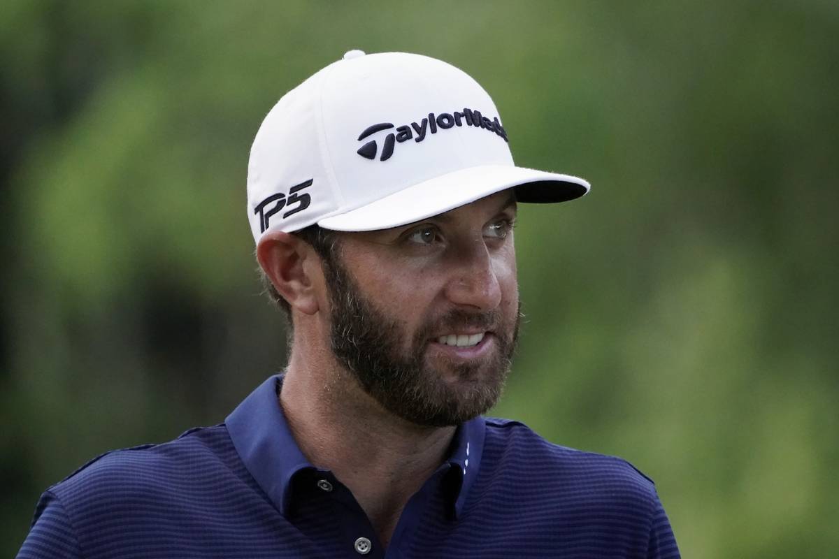 Dustin Johnson smiles as he walks to the 17th tee during the final round of the Northern Trust ...