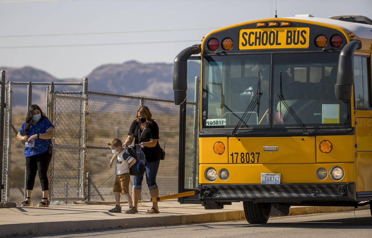 A student is assisted off the bus for the opening day of class for students at Ute Perkins Elem ...