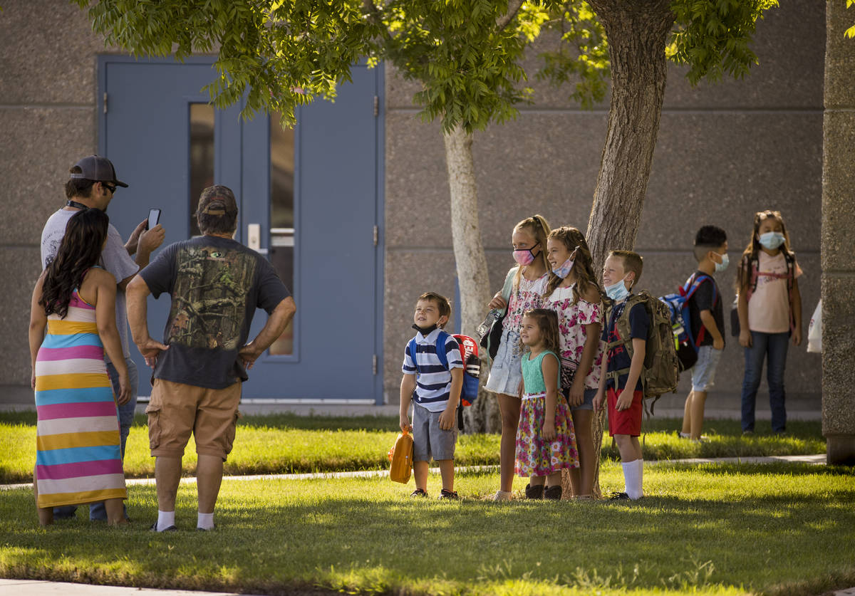 A parent takes a photo of students on opening day at Ute Perkins Elementary School with schools ...