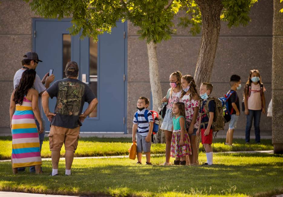 A parent takes a photo of students on opening day at Ute Perkins Elementary School with schools ...