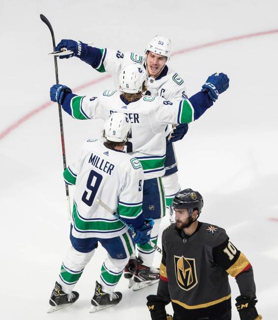 Vegas Golden Knights' Nicolas Roy (10) skates past as Vancouver Canucks' Bo Horvat (53), Brock ...