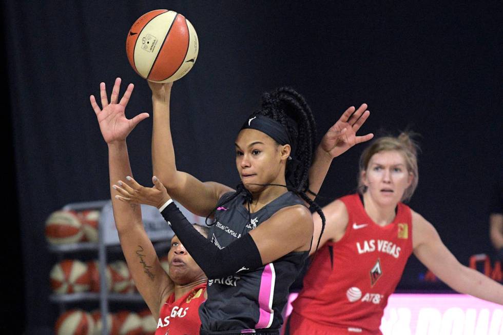 Dallas Wings forward Satou Sabally passes the ball in front of Las Vegas Aces center A'ja Wilso ...