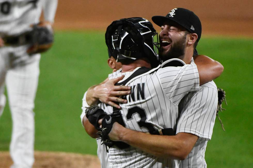 Chicago White Sox starting pitcher Lucas Giolito, right, hugs catcher James McCann and Jose Abr ...