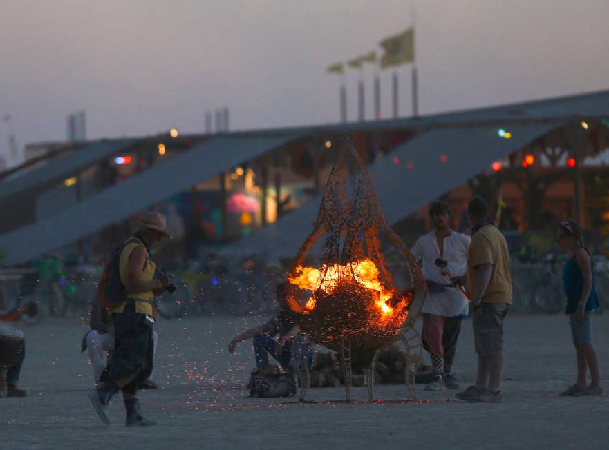 Attendees gather around a fire pit during Burning Man at the Black Rock Desert north of Reno, A ...